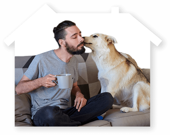 Decorative image of a man sitting on a couch with a large dog kissing him on the cheek.