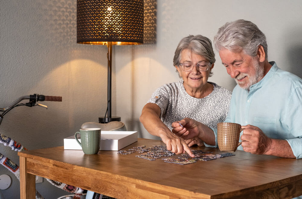 Decorative image of an elderly couple doing a jigsaw puzzle togetehr
